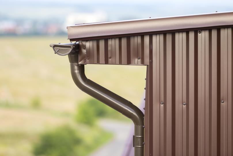 A gutter cleaning professional cleaning gutters on a house