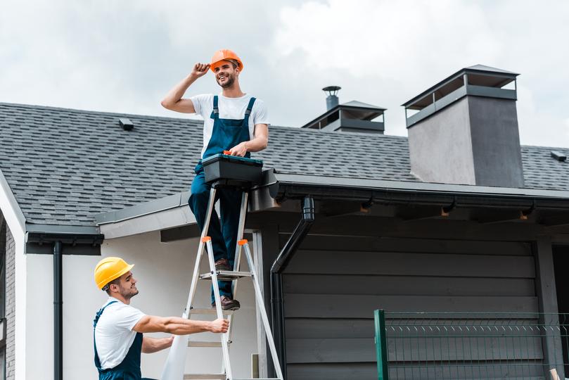 A gutter cleaning professional cleaning gutters on a house