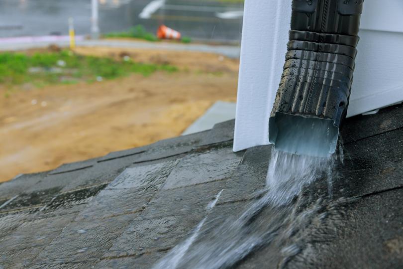 A gutter cleaning professional cleaning gutters on a house