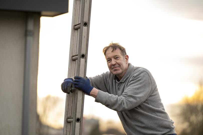 A gutter cleaning professional cleaning gutters on a house