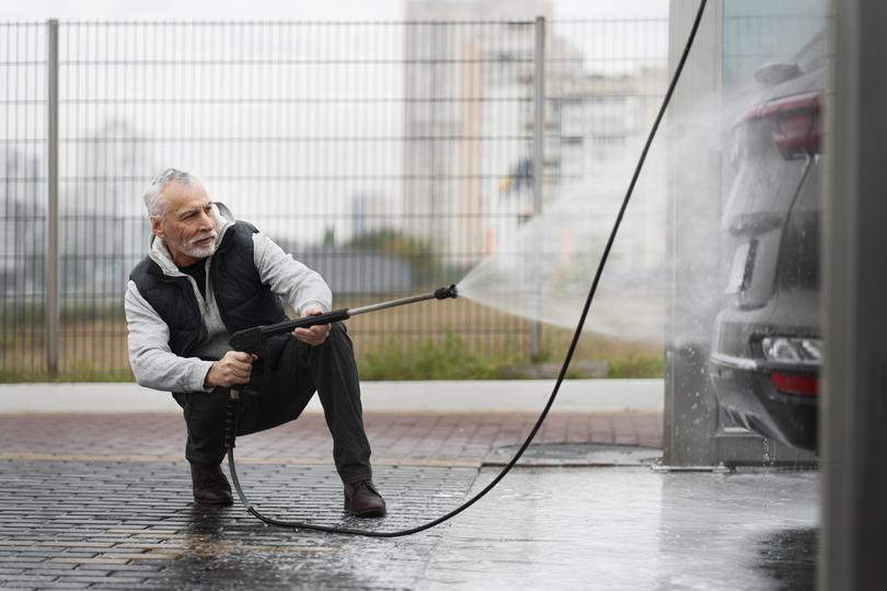 A pressure washing professional cleaning a driveway