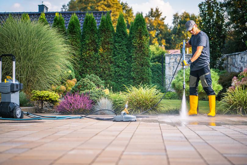 A pressure washing professional cleaning a driveway