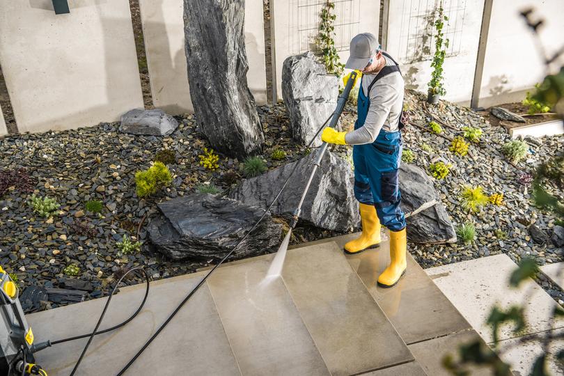 A pressure washing professional cleaning a driveway